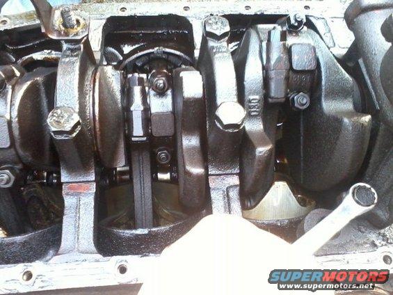 Engine crankshaft and connecting rods with visible text '080' on one rod