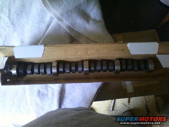 Camshaft in a cardboard box, with metal lobes and gear