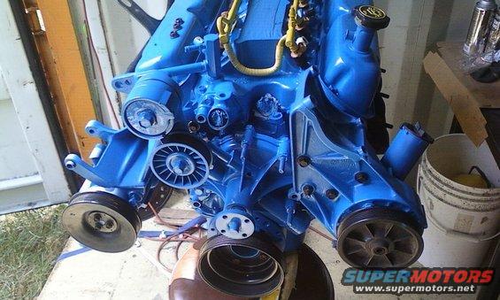 Blue engine block with pulleys and hoses, Supermotors logo visible