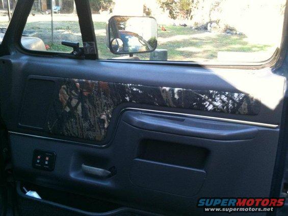 Interior door panel with camouflage insert and power window controls