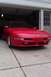 1996 Ford Probe - A red 1996 Ford Probe is parked in a driveway in front of an open garage door.