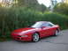 1996 Ford Probe - Red 1996 Ford Probe coupe parked on asphalt with tall grass in the background.