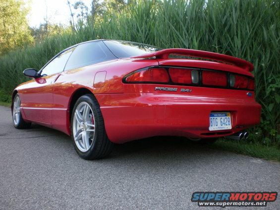 Red 1996 Ford Probe coupe from rear-left, showing spoiler, taillights, and Michigan license plate BTG 6428