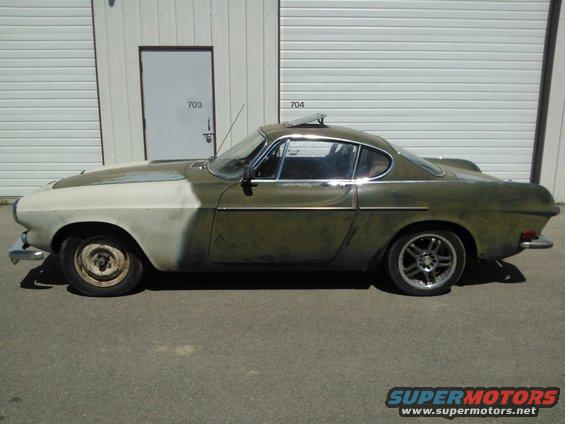 Side view of a 1969 Volvo P1800 with primer on the hood and faded green paint