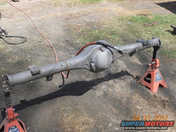 Rear axle assembly on jack stands, with a red hose connected