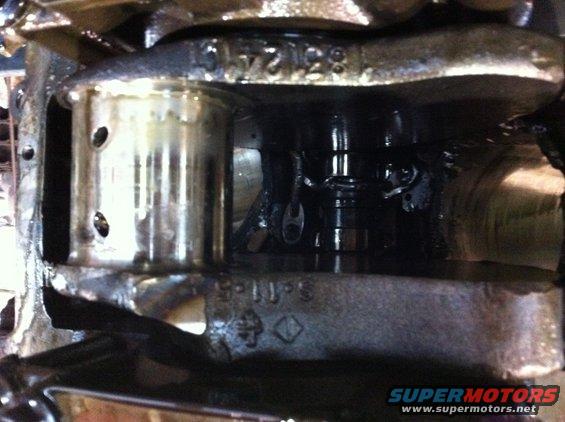 Close-up of engine crankshaft and connecting rod with visible part numbers