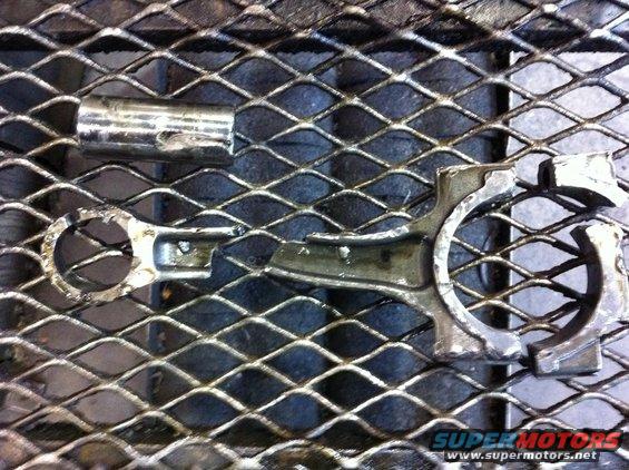 Broken engine connecting rod and cap on a metal grate