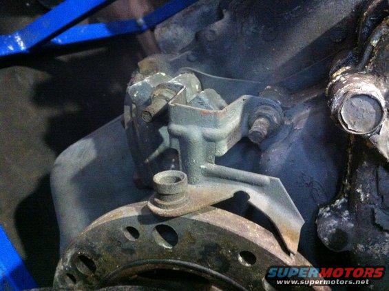 close-up of a rusty engine bracket and part of a brake rotor