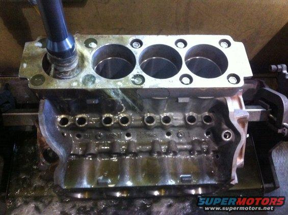 Engine block with cylinders being machined by a tool