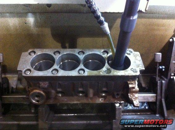 Engine block cylinders being honed on a machine
