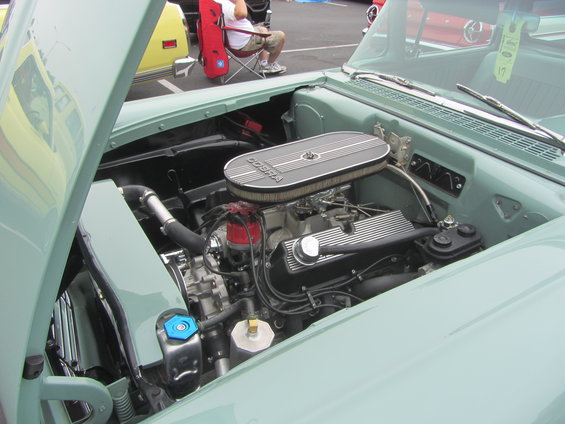 Engine bay of a light green car with a Cobra air cleaner and V8 engine