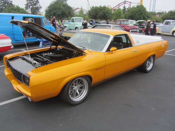 Yellow 1970s ranchero with hood open, showing engine