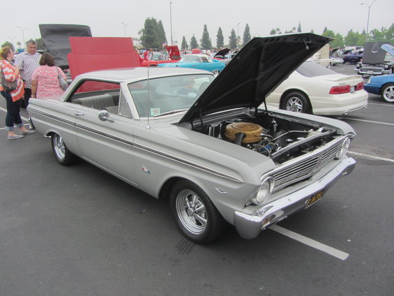 1964 Ford Falcon with hood open, showing engine. Parked at an outdoor car show
