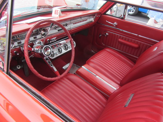 red car interior with bench seats, steering wheel, and dashboard