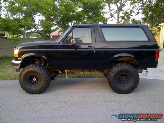 Black 1995 Ford Bronco side view, lifted with large tires