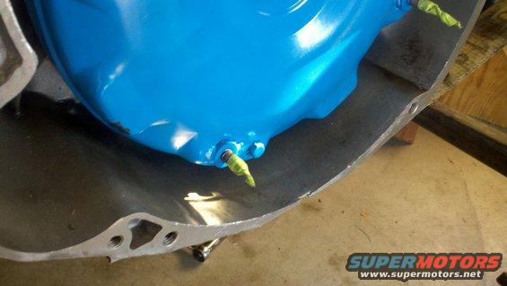 Blue painted part with yellow taped fitting inside a metal casing