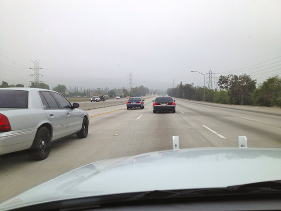 Silver 2004 Ford Crown Victoria driving on a foggy highway, side view