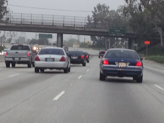Rear view of a silver 2004 Ford Crown Victoria on the highway