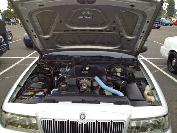2004 Ford Crown Victoria engine bay with hood open, showing V8 engine and parts