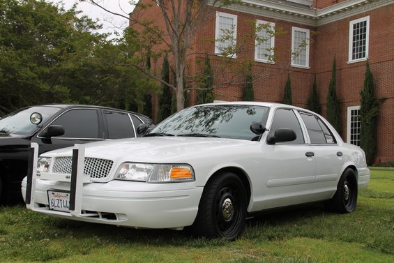 White 2004 Ford Crown Victoria police car with push bumper and black wheels