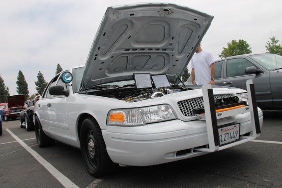 White 2004 Ford Crown Victoria with hood open, showing engine modifications and a push bar