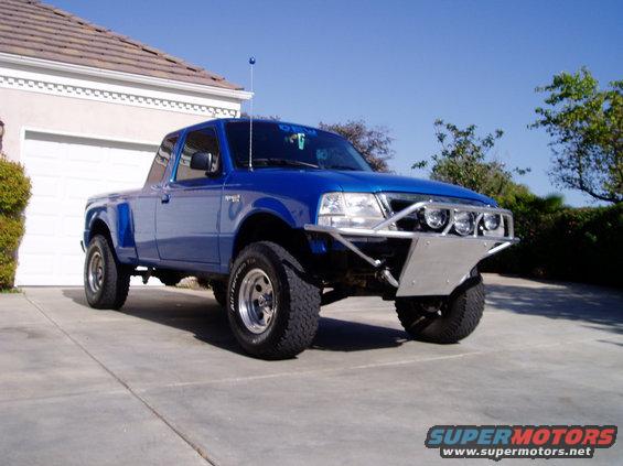 Blue 1998 Ford Ranger pickup truck with custom bumper and off-road tires, parked in a driveway