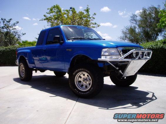 Blue Ford Ranger pickup truck with custom front bumper and off-road tires parked outside