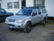 2003 Nissan Frontier - Silver 2003 Nissan Frontier pickup truck with camper shell and roof rack.