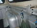2003 Nissan Frontier - Interior view of a truck bed showing a metal tie-down track system with carabiners attached.