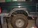 1992 Ford Bronco - The rear section of a dark green SUV is shown, focusing on the tire and suspension components.