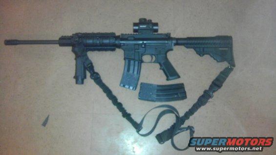AR-15 style rifle with bipod, red dot sight, and two magazines