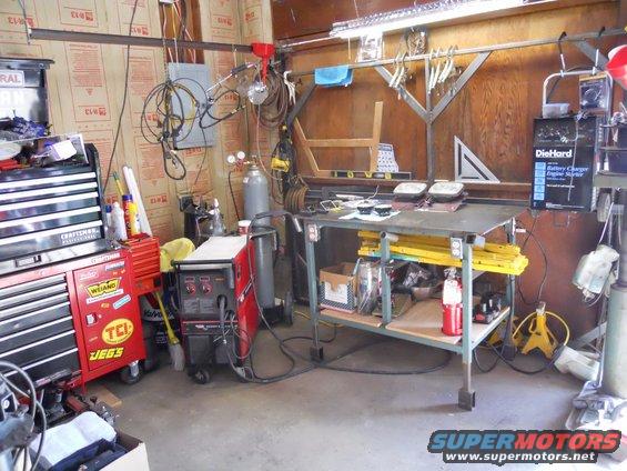 Workshop scene with welding equipment, tool chests, and a workbench