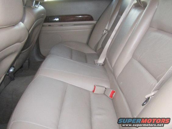 Rear leather seats with beige upholstery and seatbelts