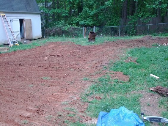 Backyard scene with shed, ladder, and cleared dirt area