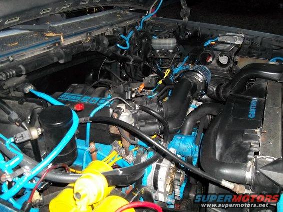 Engine bay with blue hoses and painted components. Aftermarket air intake visible
