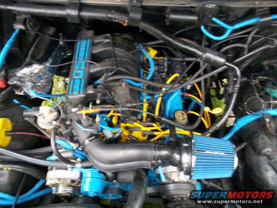 Engine bay with blue and yellow wires, blue air filter, and '4.0L' label on the intake manifold