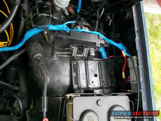 Engine bay with blue taped wiring and a Supermotors.net watermark