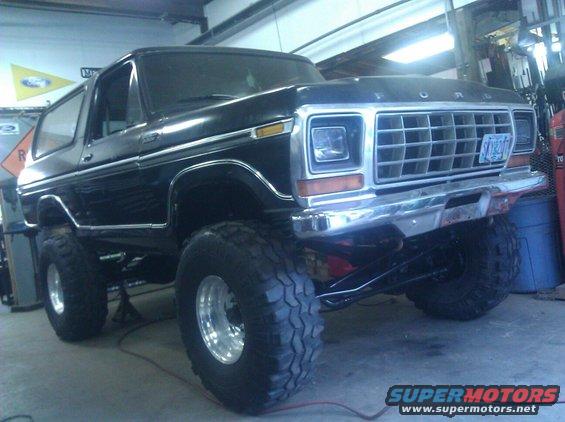 Black Ford Bronco lifted with big tires, parked inside a garage