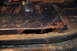 1986 Ford Bronco - A section of a vehicle's undercarriage shows significant rust and a large hole.
