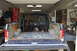 1986 Ford Bronco - Disassembled blue pickup truck interior, with dashboard and empty bed visible. A Confederate flag hangs in the background.