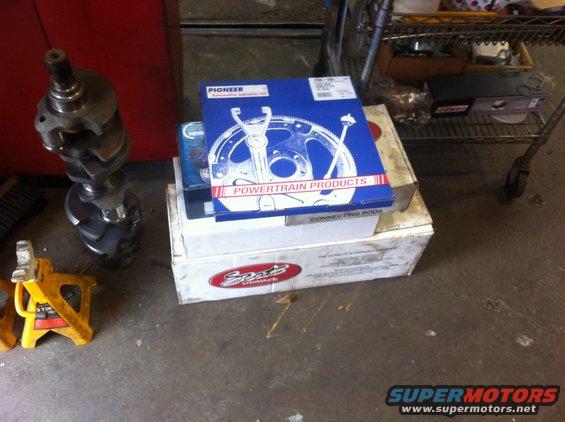 Engine crankshaft, Pioneer "Powertrain Products" connecting rods box, and other engine parts boxes on garage floor