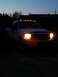 2000 Ford F-250 - A white pickup truck is parked outside at dusk, its headlights and roof marker lights illuminated.