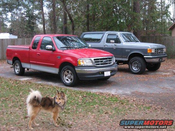 Red 1997-2003 Ford F-150 parked next to a gray Ford Bronco