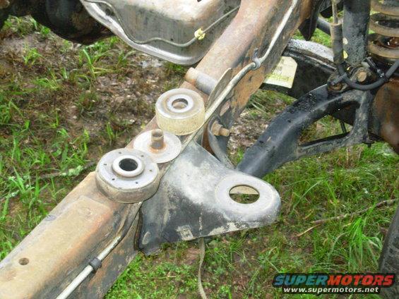 bodymtr2.jpg The other body mounts are much simpler to remove.  Simply back out the bolt until no threads are showing below the nut, then strike the bolt head sharply with a ball-peen or dead-blow hammer to separate the sleeves.  It's slightly more effective to do this WHILE the body is still resting on the mounts because that preloads the rubber, making it bounce less.  The #2 insulators are slightly different from #3-5, so keep their parts separate from those.

[url=http://www.supermotors.net/registry/media/194329][img]http://www.supermotors.net/getfile/194329/thumbnail/body-mounts.jpg[/img][/url] . [url=http://www.supermotors.net/registry/media/72356][img]http://www.supermotors.net/getfile/72356/thumbnail/energy-body-mounts.jpg[/img][/url] . [url=http://www.supermotors.net/registry/media/934266][img]http://www.supermotors.net/getfile/934266/thumbnail/11bodymtglue.jpg[/img][/url] . [url=http://www.supermotors.net/registry/media/969977][img]http://www.supermotors.net/getfile/969977/thumbnail/29tubalign.jpg[/img][/url] . [url=http://www.supermotors.net/registry/media/970533][img]http://www.supermotors.net/getfile/970533/thumbnail/drainwasher.jpg[/img][/url]