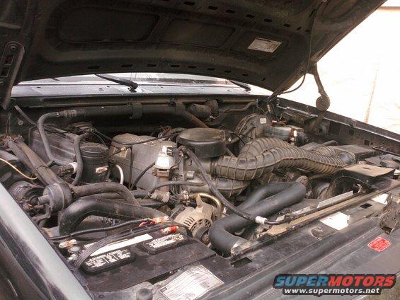 1994 Ford Bronco engine bay with V8 engine, battery, and air intake visible