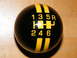 2004 Ford Crown Victoria - A black shift knob with yellow stripes displays a 6-speed manual gear pattern and reverse.