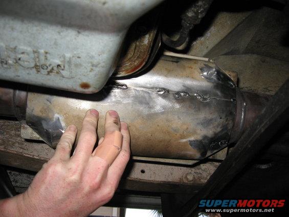 Exhaust pipe with welds and a hand touching it
