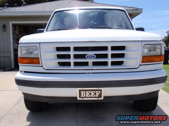 White Ford truck front end with a horizontal grille and a license plate that says BEEF