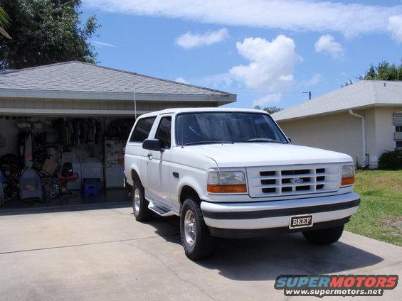White 1995 Ford Bronco parked in driveway in front of garage