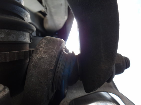 Close-up of a car's front suspension, showing a ball joint and control arm assembly